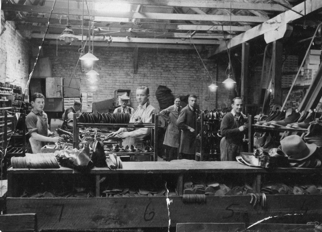 Historical black and white photograph of workers in a factory setting.