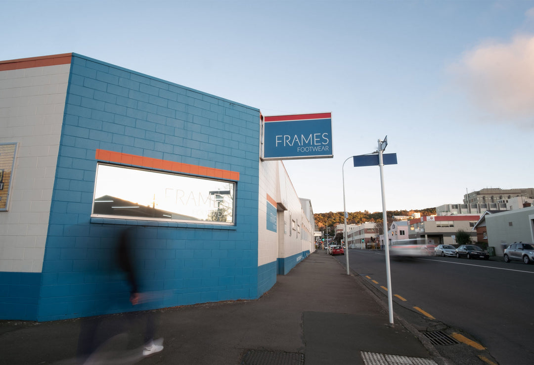 Blue building with 'FRAMES' sign on a street corner